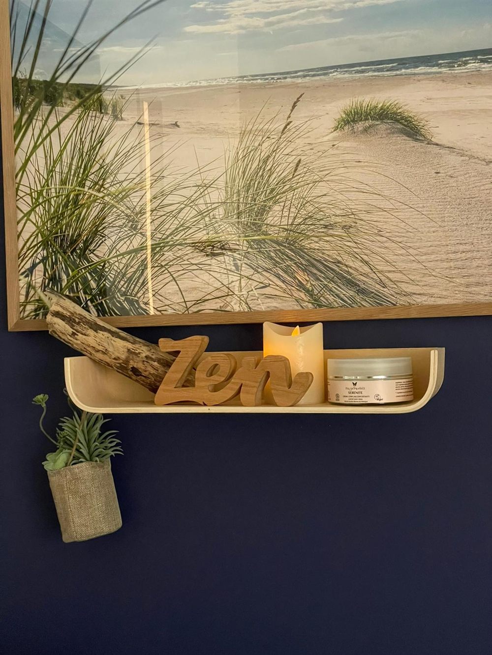 Détail de l'étagère : bois flotté, bougie et crème